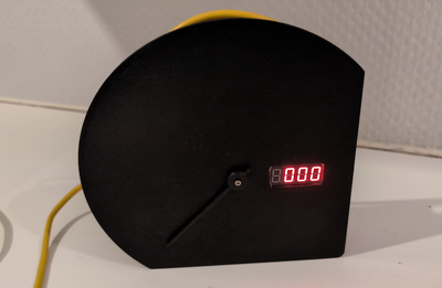 A sim racing speedometer, in a 3D printed shell, dial showing engine RPM and a four-digit seven-segment display showing vehicle speed